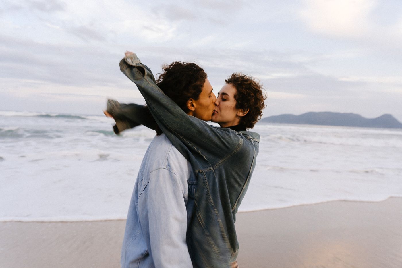 Casal na praia, beijo ao vento